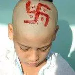 Swastika painted on the shaven head of a hindu boy during a initiation ritual